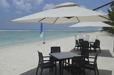 A table and chairs set up under an umbrella on a resort beach