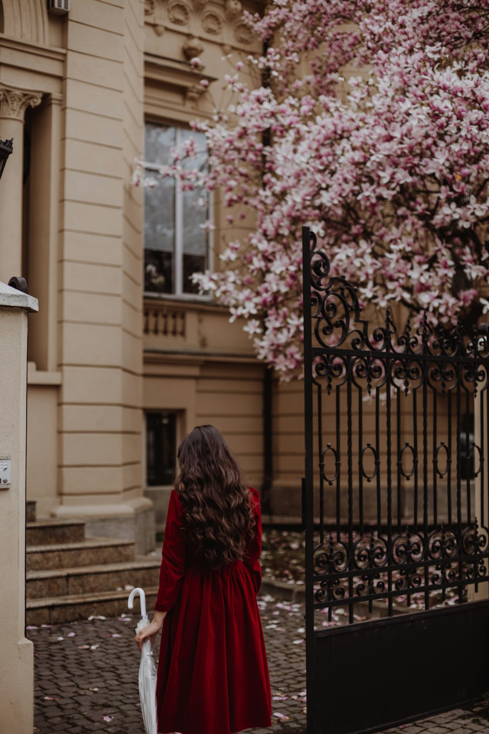 a woman in a red dress is walking down the street