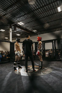 a couple of people standing in a boxing ring