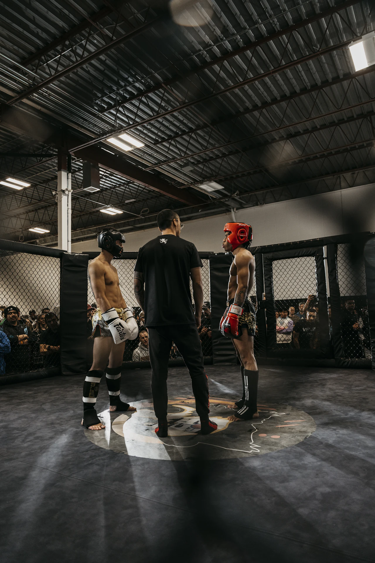 Atletas y público alrededor de un ring durante un evento deportivo