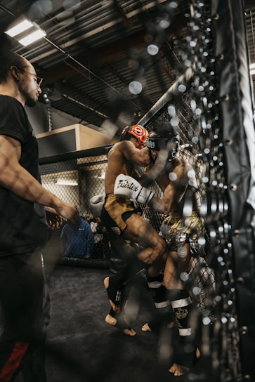 a man standing next to another man in a cage