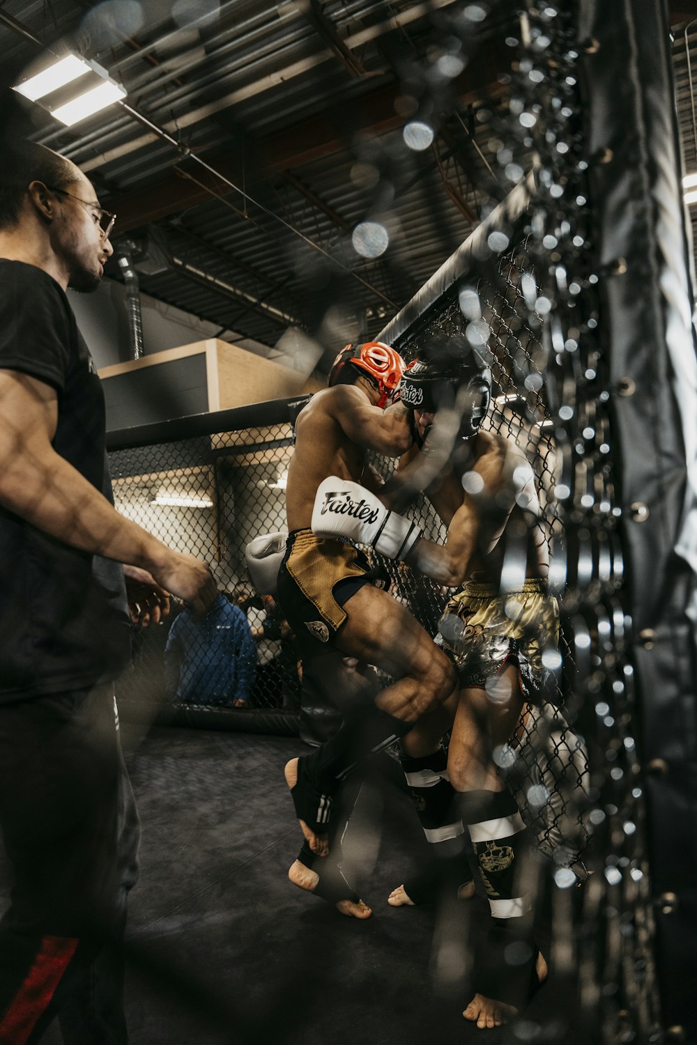 a man standing next to another man in a cage