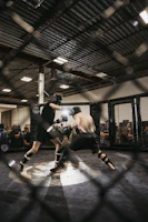 A dramatic UFC fight scene with two fighters exchanging powerful strikes under bright arena lights.