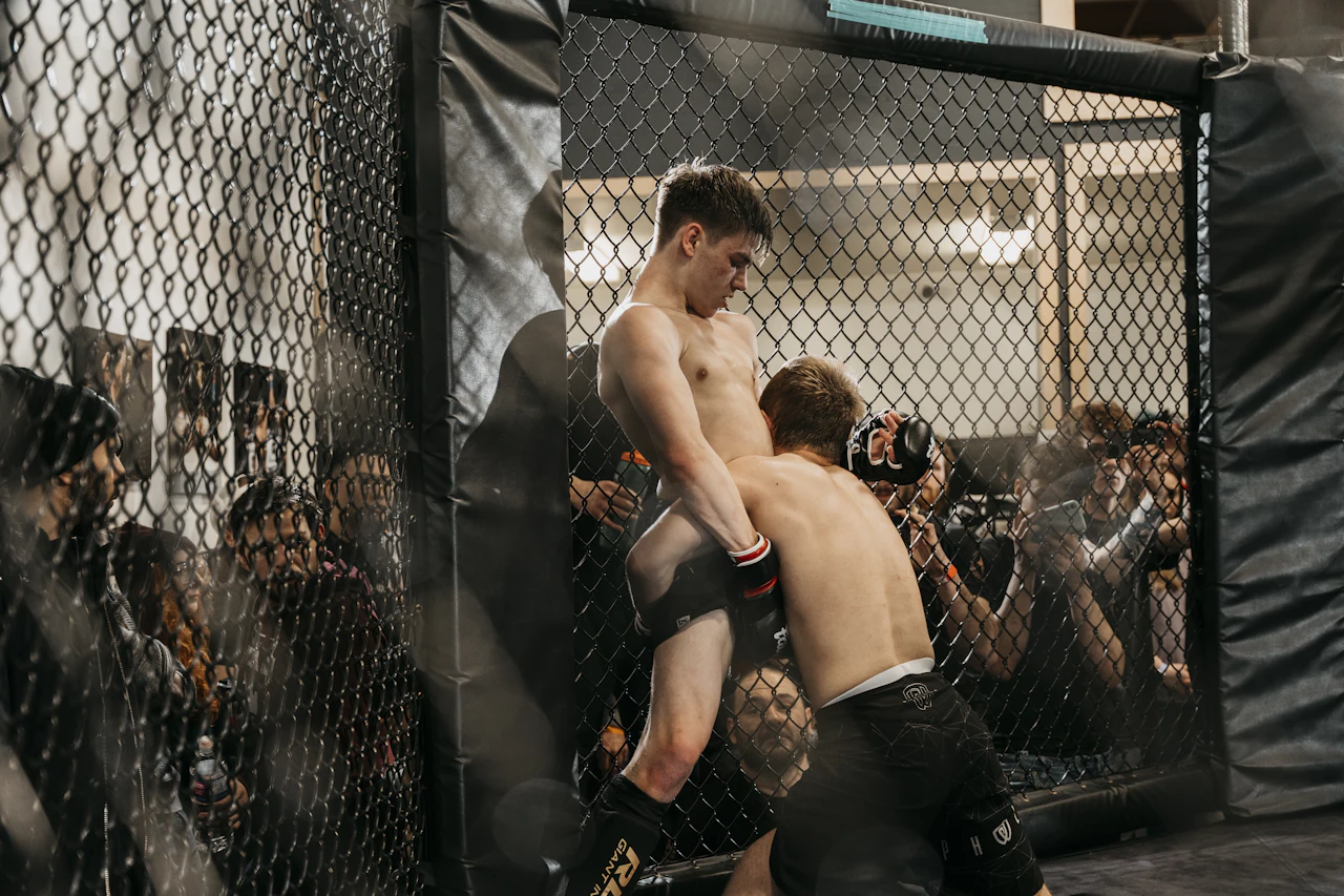 Peleadores dentro de una jaula durante un evento de artes marciales