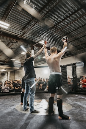 a couple of men standing on top of a wrestling ring