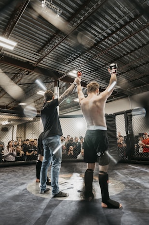 a couple of men standing on top of a wrestling ring