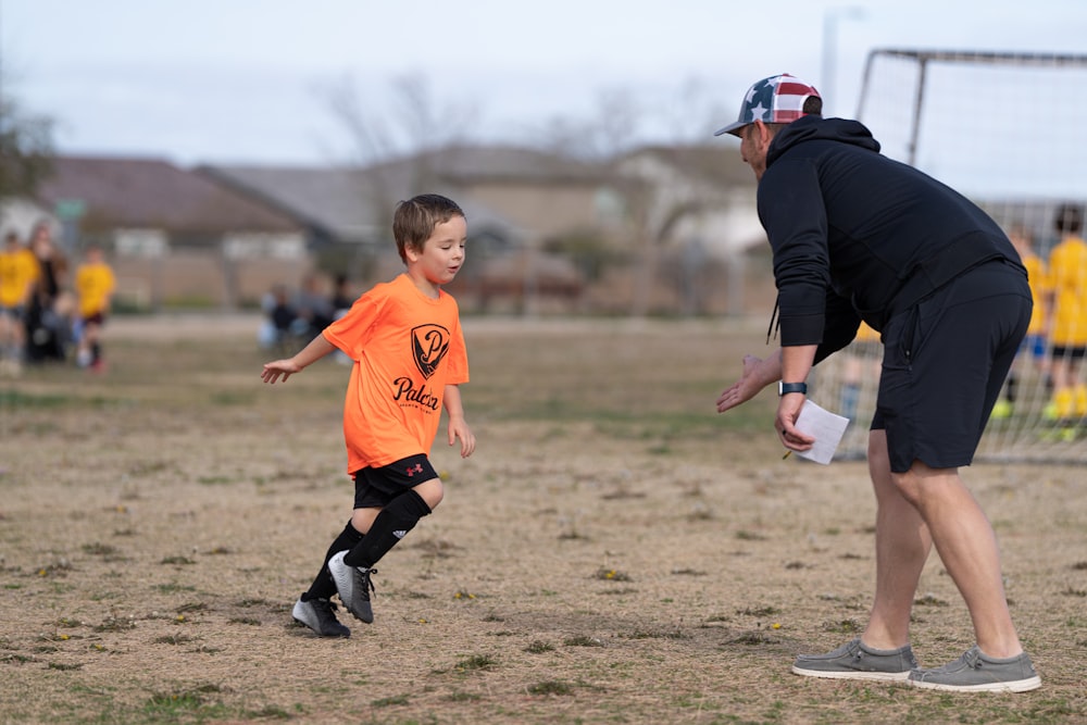 a man and a young boy playing a game of soccer