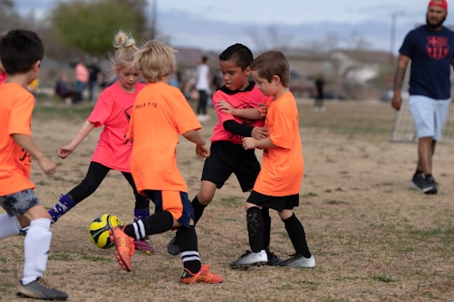 Volunteers coaching kids during a lively soccer practice on a sunny Saturday.