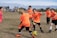 Photo of children practicing soccer drills on a sunny field while wearing team jerseys.