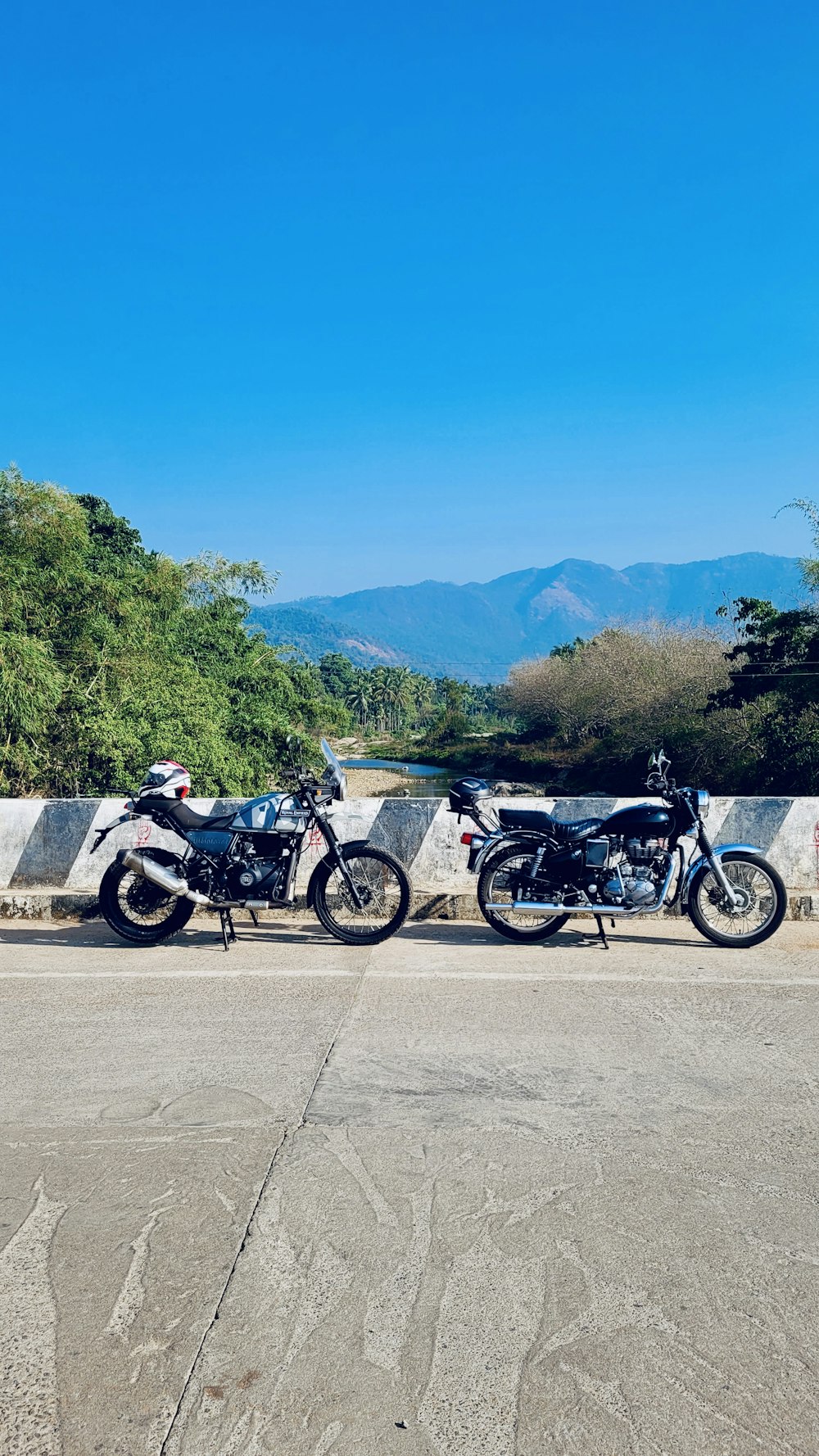 two motorcycles parked on the side of a road