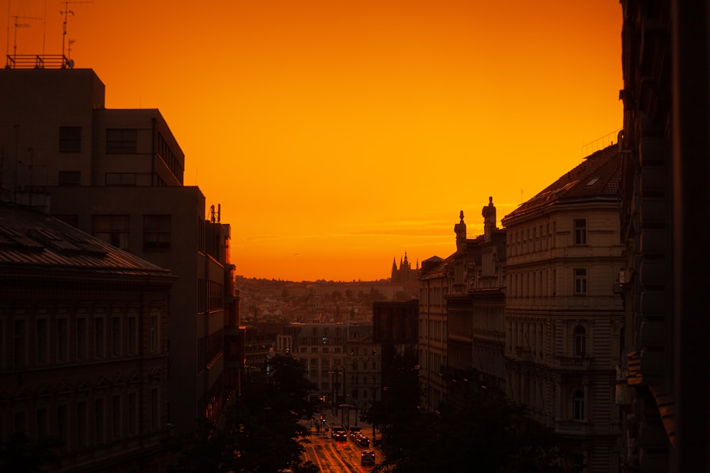 the sun is setting over a city with tall buildings