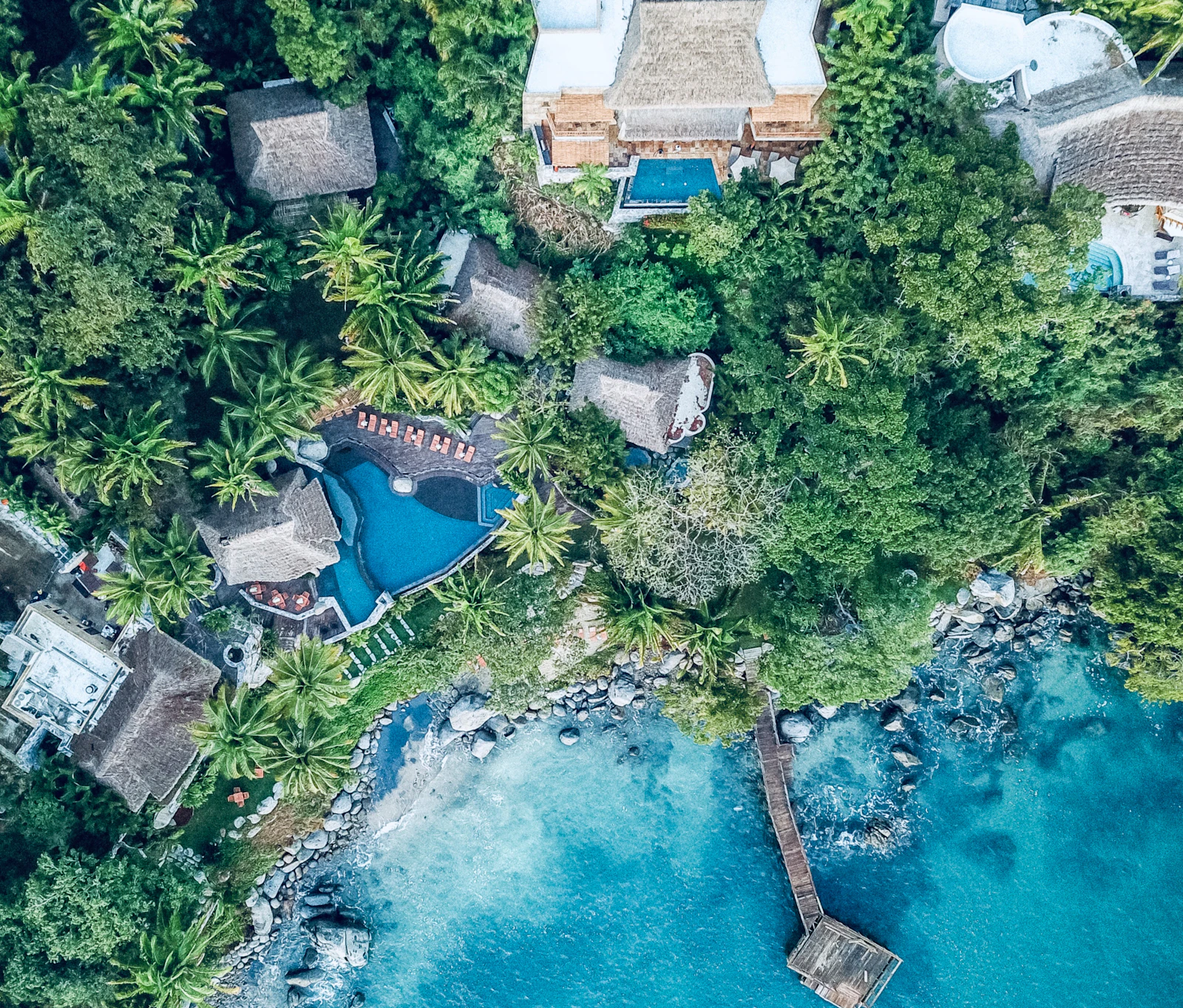 Sayulita from the air, pools and roofs among the jungle above the bay