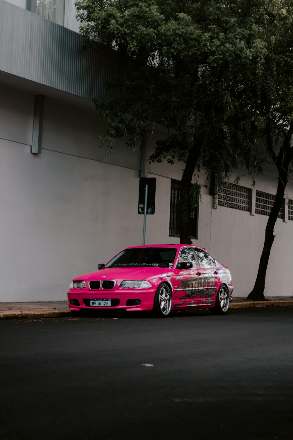 a pink car parked on the side of the road