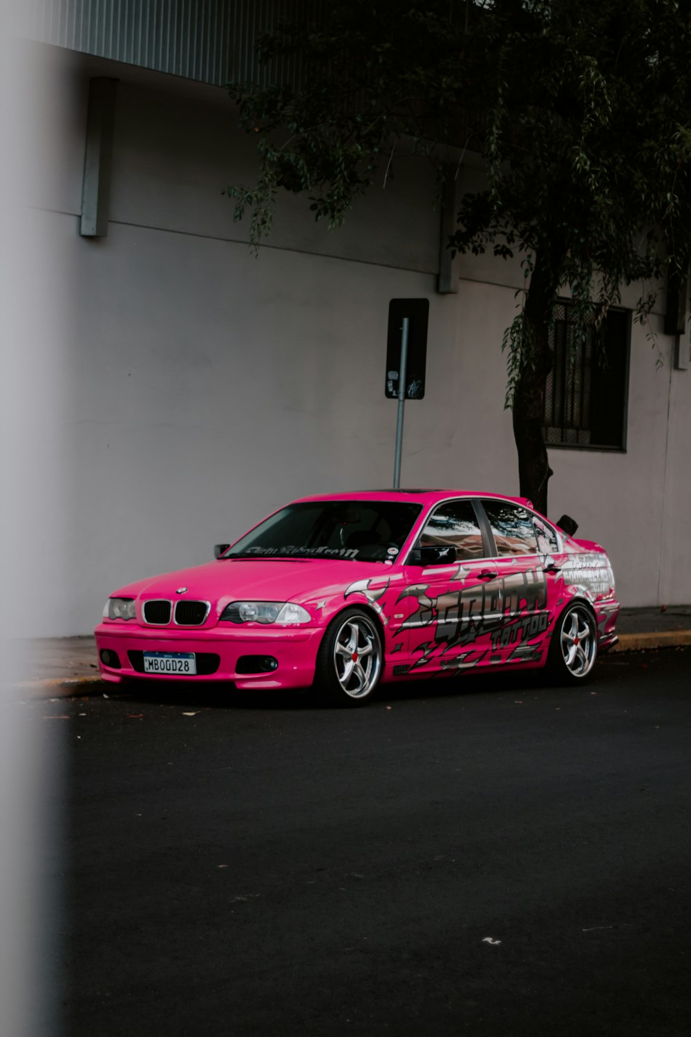 a pink car parked on the side of the road