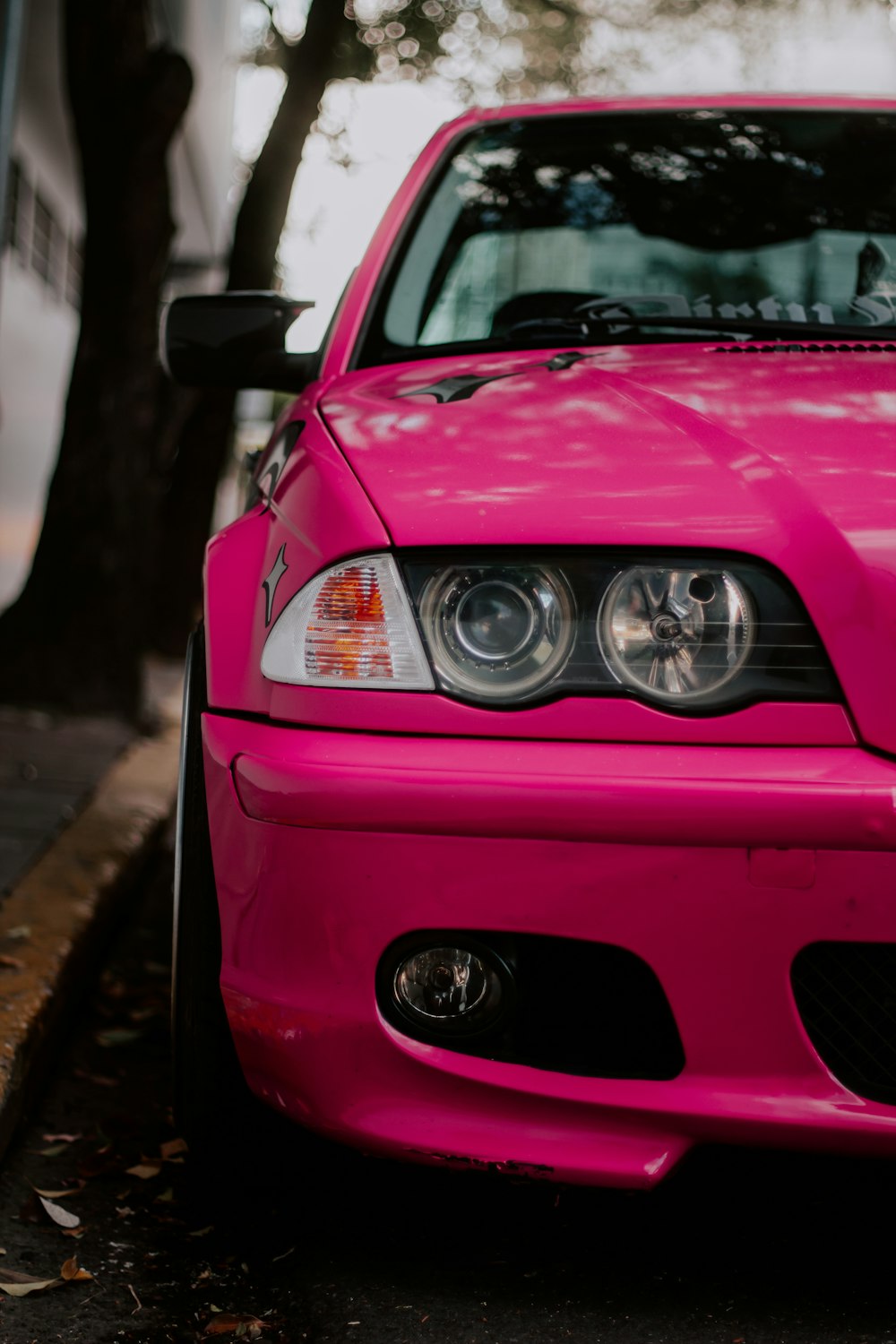 a pink car parked on the side of the road