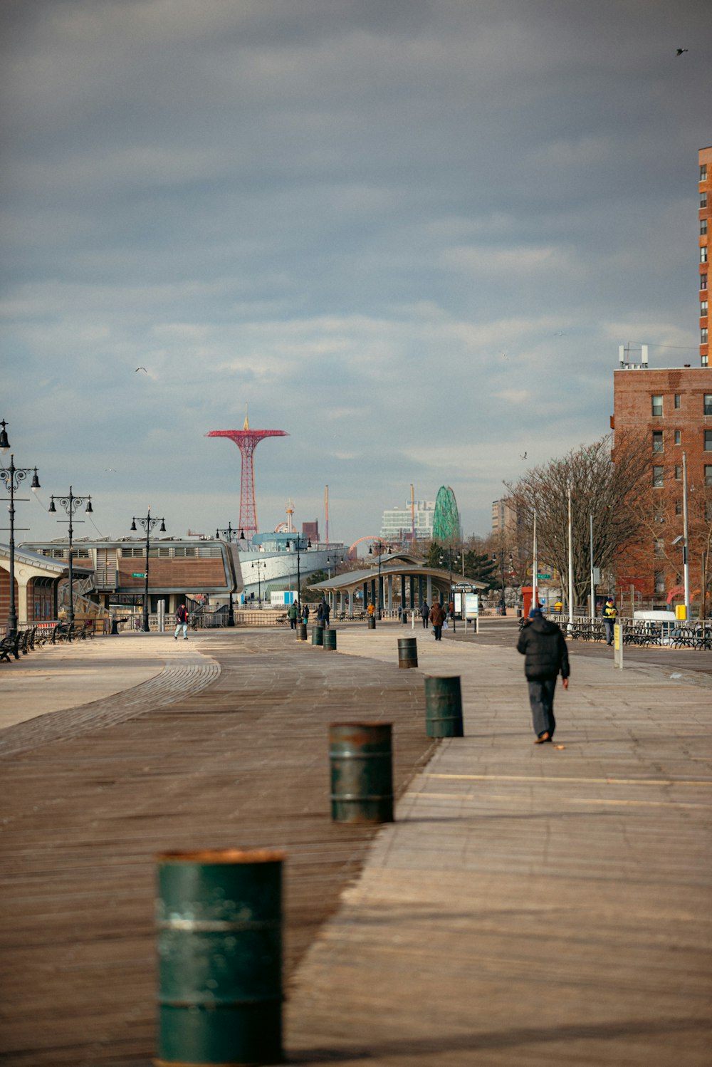 a person walking on a boardwalk near a city