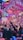 A vibrant indoor event with colorful confetti filling the air. A large crowd of people are gathered, many with raised arms and smartphones capturing the moment. The atmosphere is lively with dynamic lighting casting hues of purple, pink, and blue over the scene.