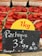 Baskets of strawberries are displayed in a market setting with a sign indicating a price of 3.99 euros per kilogram, with the product labeled as originating from Senegal. A small portion of what appears to be watermelon is visible at the bottom of the image.