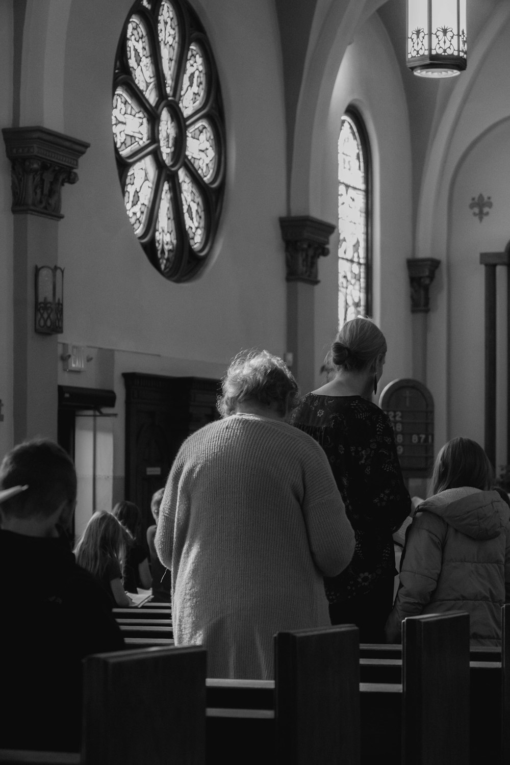 a black and white photo of people in a church