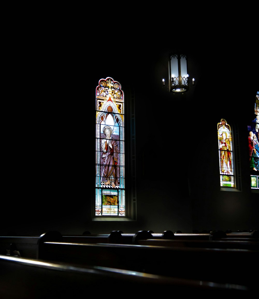 three stained glass windows in a dark room