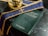 A dark marble table holds a book titled 'Pastoral Care of the Sick' with bilingual text. A purple stole with gold embroidery and a small glass container filled with liquid are placed nearby.