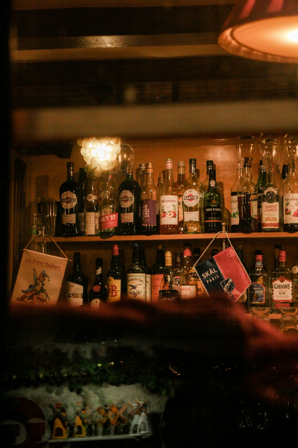 a shelf filled with bottles of alcohol and liquor glasses