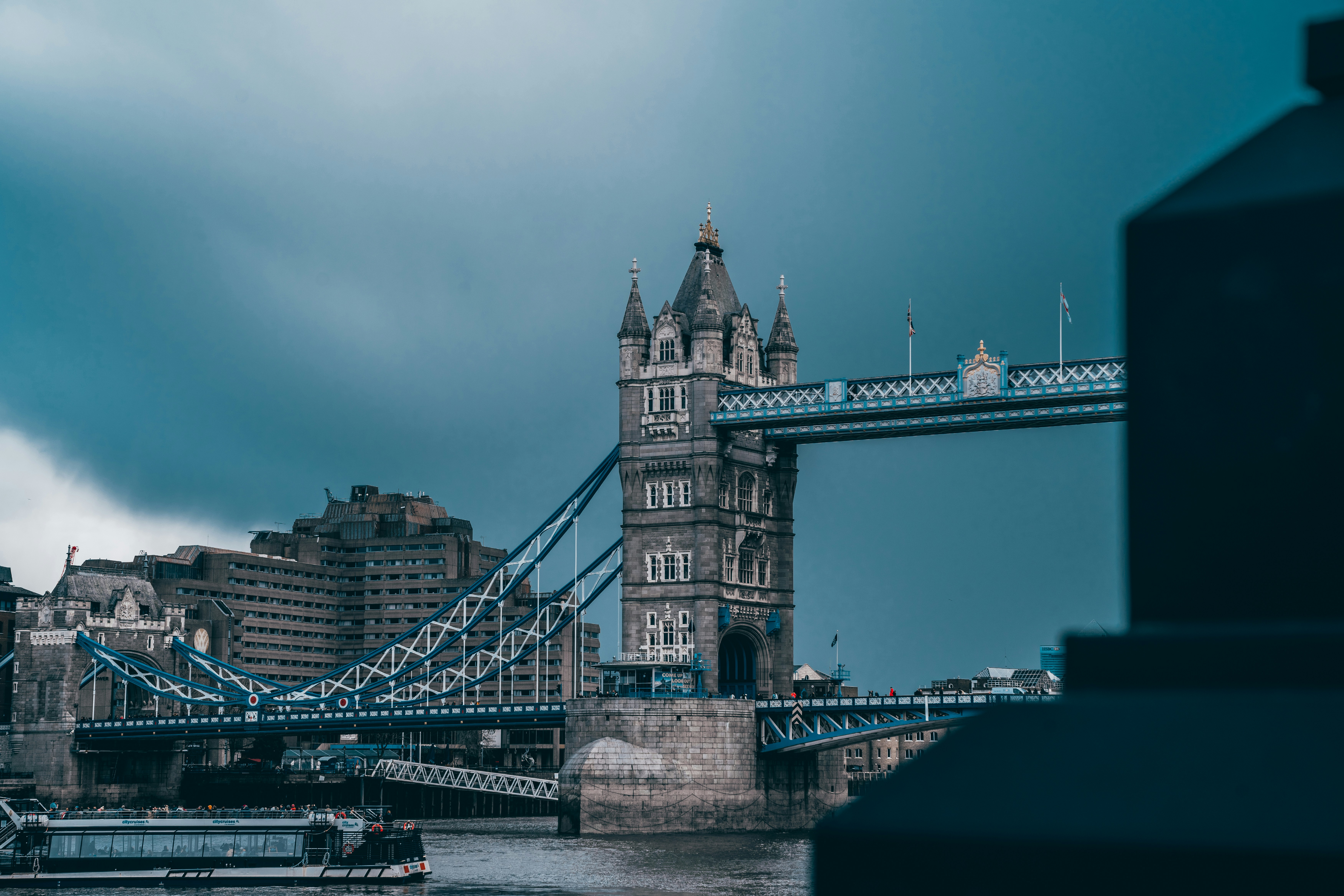 a view of the tower bridge from across the river, Tower Bridge in London, UK, with cloudy sky background.