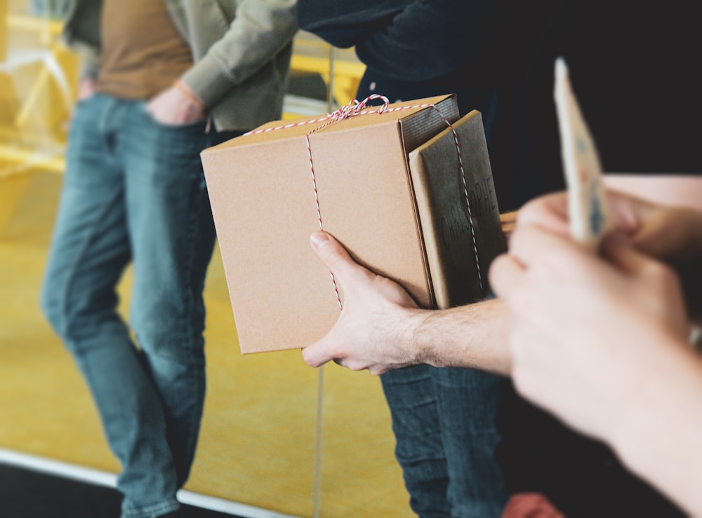 a person holding a brown box with a string on it