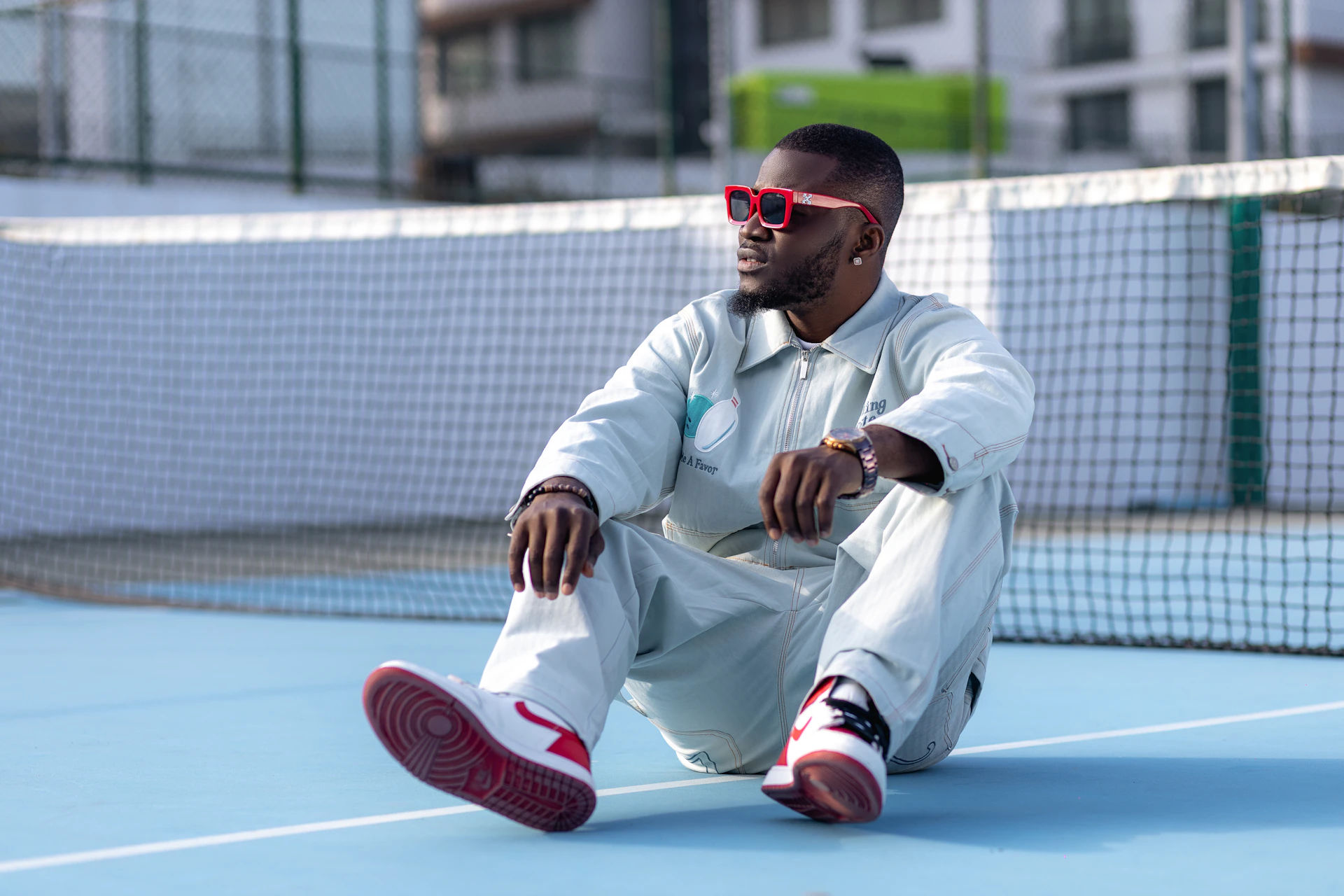 a man sitting on top of a tennis court