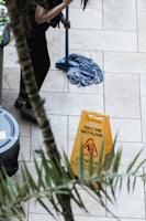 a woman sweeping the floor with a mop