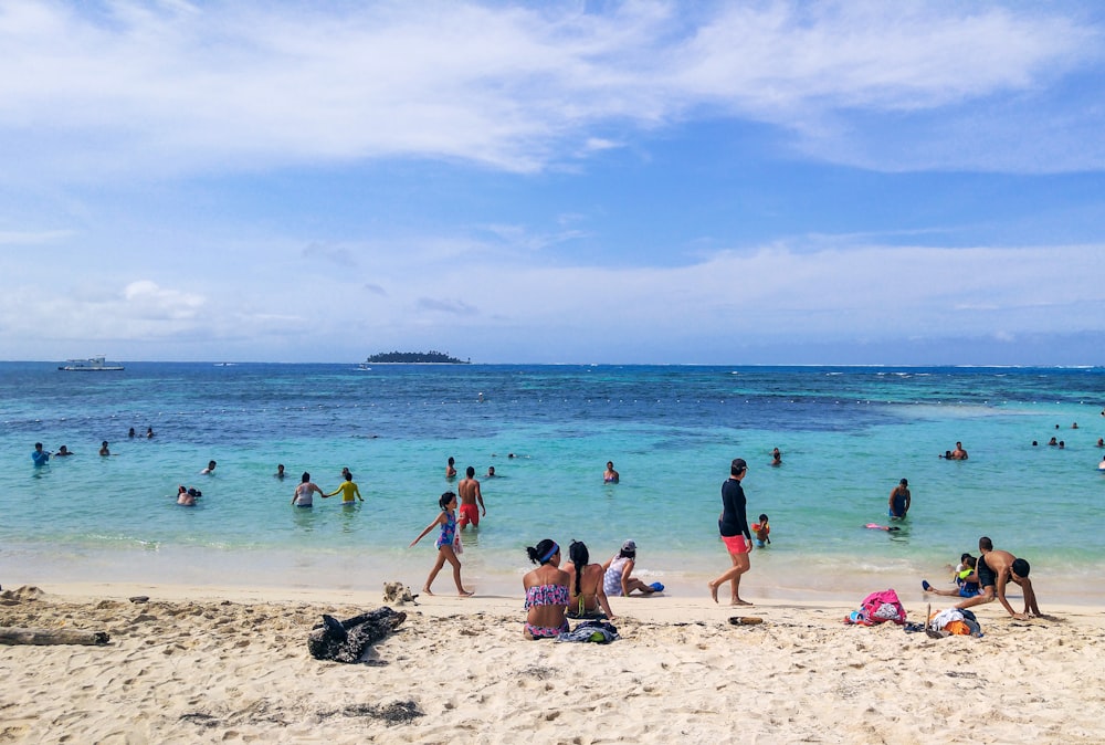 a group of people standing on top of a sandy beach