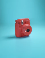 a red camera sitting on top of a blue surface