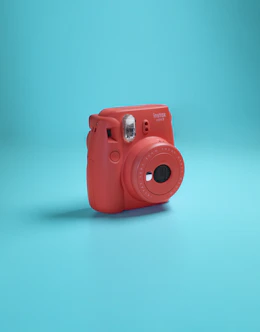 a red camera sitting on top of a blue surface