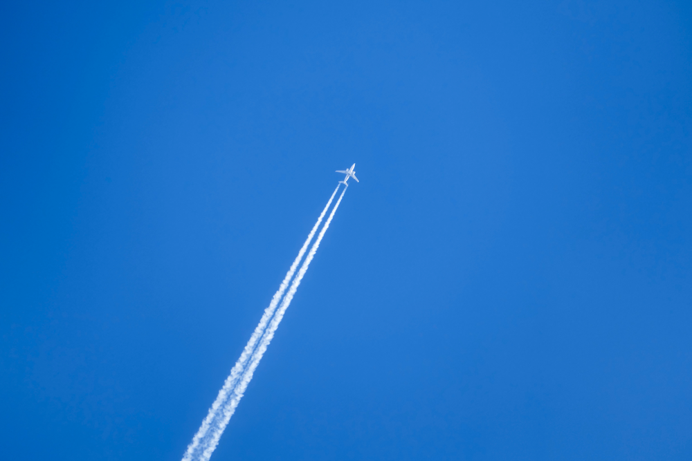 Ein Flugzeug fliegt hoch am Himmel