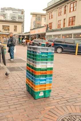 A vibrant display of colorful plastic crates stacked neatly in a bustling market setting.