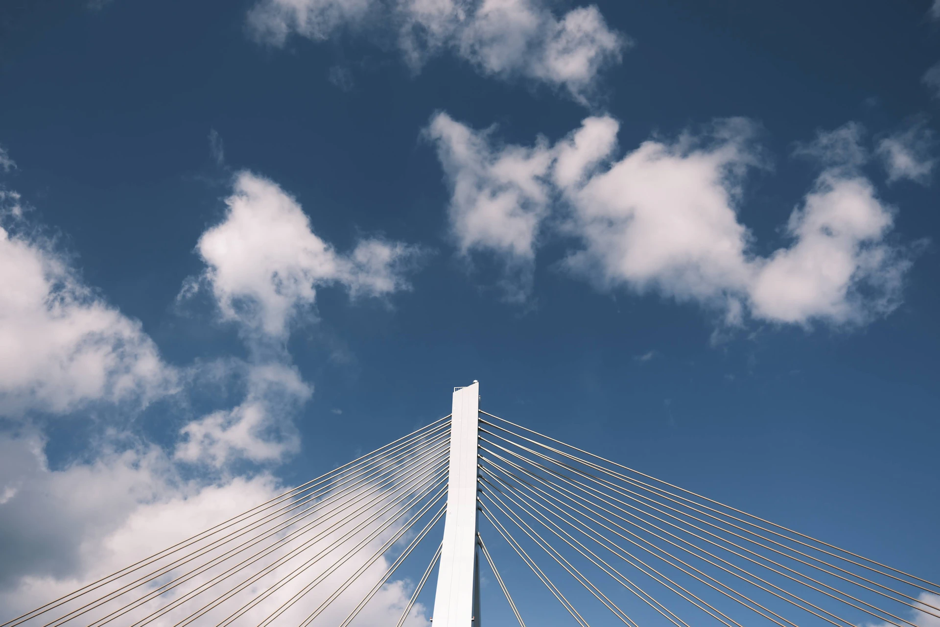 a very tall white bridge with a sky background