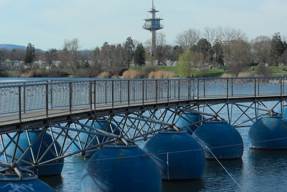 a bridge over a body of water with blue buoys