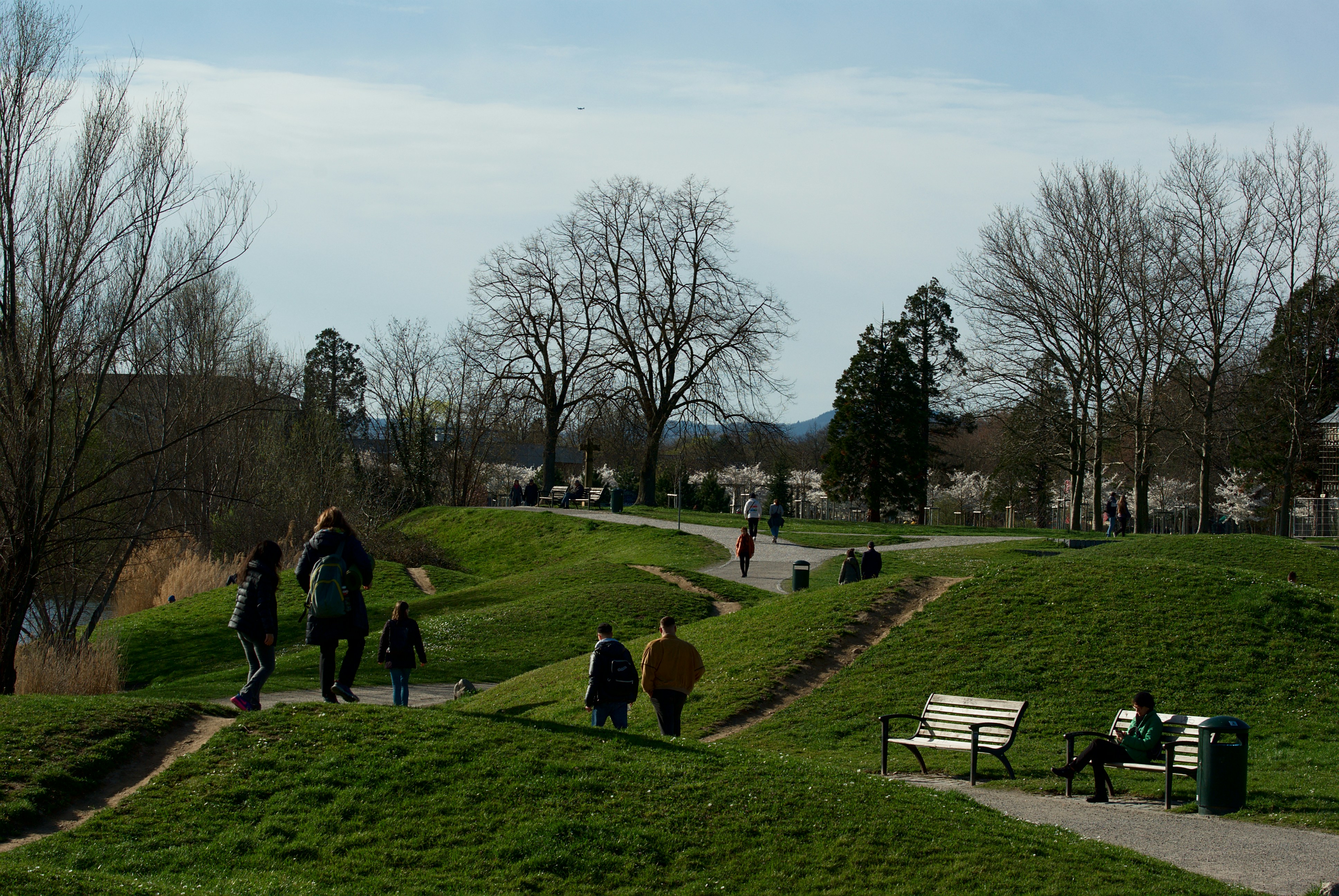 a group of people walking up a hill next to a park