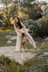 A staff member gently playing with a cheerful dog in an outdoor play area.