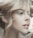 A close-up profile of a person with light hair elegantly styled. The image highlights soft facial features and natural makeup, creating an artistic and serene portrait.