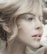 A close-up profile of a person with light hair elegantly styled. The image highlights soft facial features and natural makeup, creating an artistic and serene portrait.