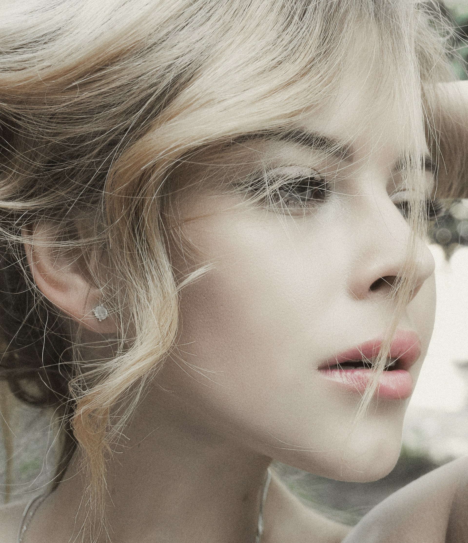 Elegant portrait of a client with perfectly designed eyebrows and smooth, luminous blonde balayage.