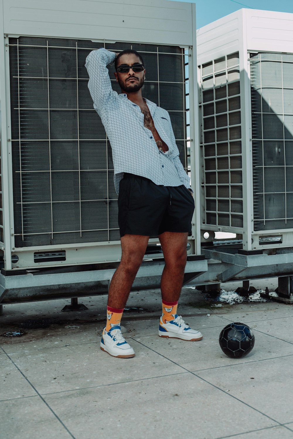 a man standing next to a black ball