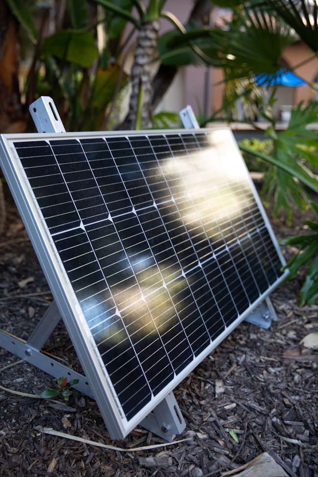 a solar panel sitting on the ground in a garden