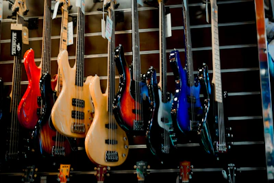 Vibrant red bass guitar hanging on a display rack in a cozy shop corner.