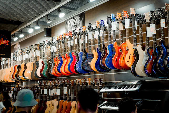 A vibrant display of various musical instruments including guitars, violins, and keyboards in a cozy store setting.