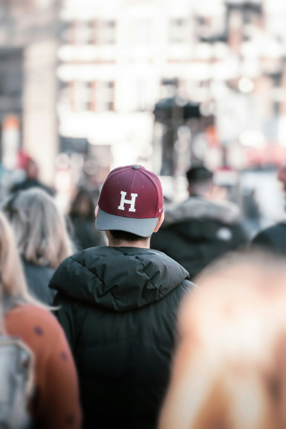 a person wearing a hat standing in the middle of a crowd