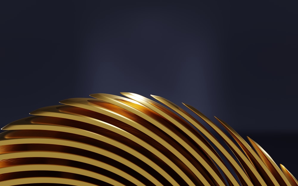 a close up of a gold object with a dark background