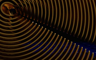 A sleek, brushed gold geometric pattern overlaying a deep midnight blue background, evoking cosmic energy.