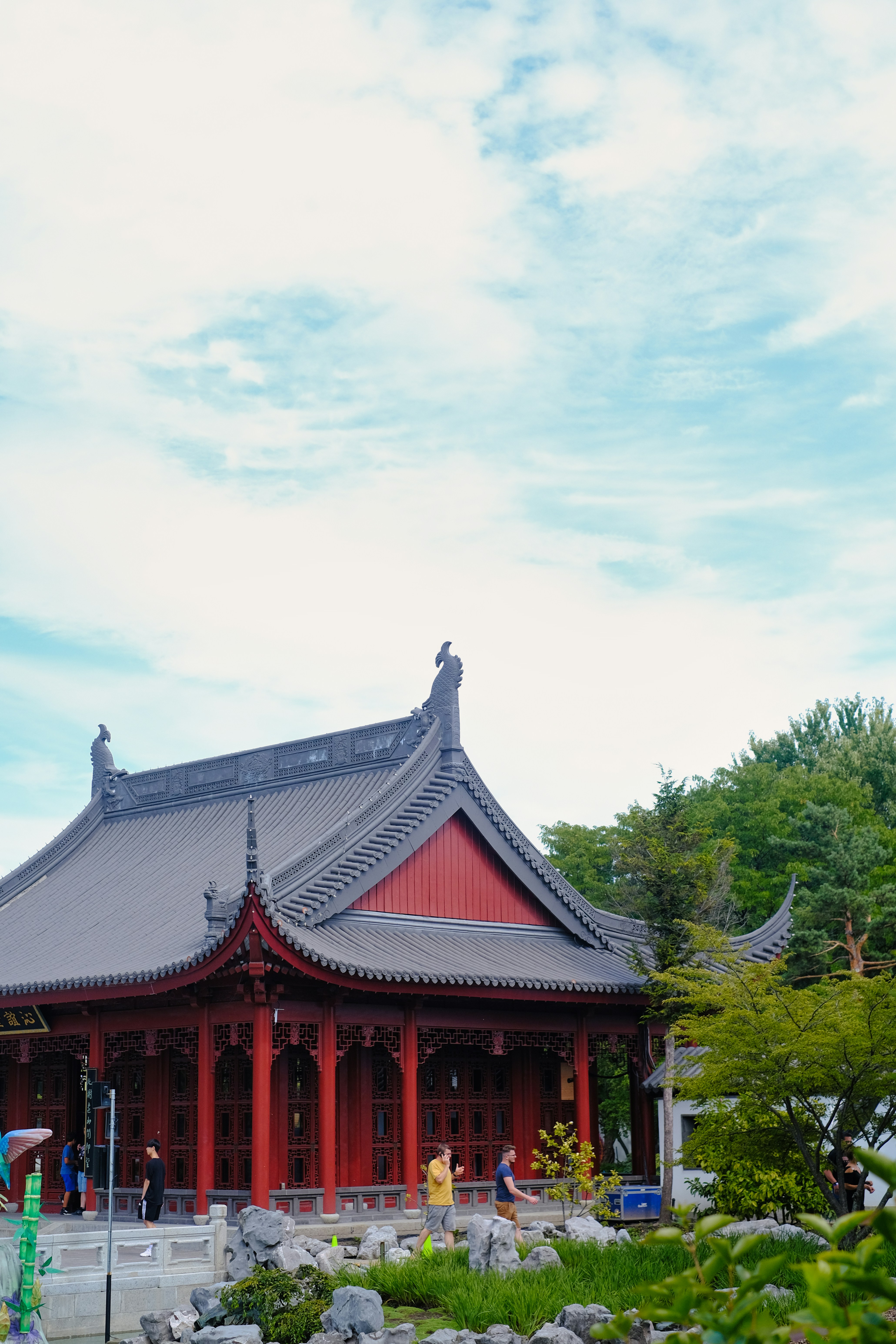 a building with a red roof surrounded by greenery